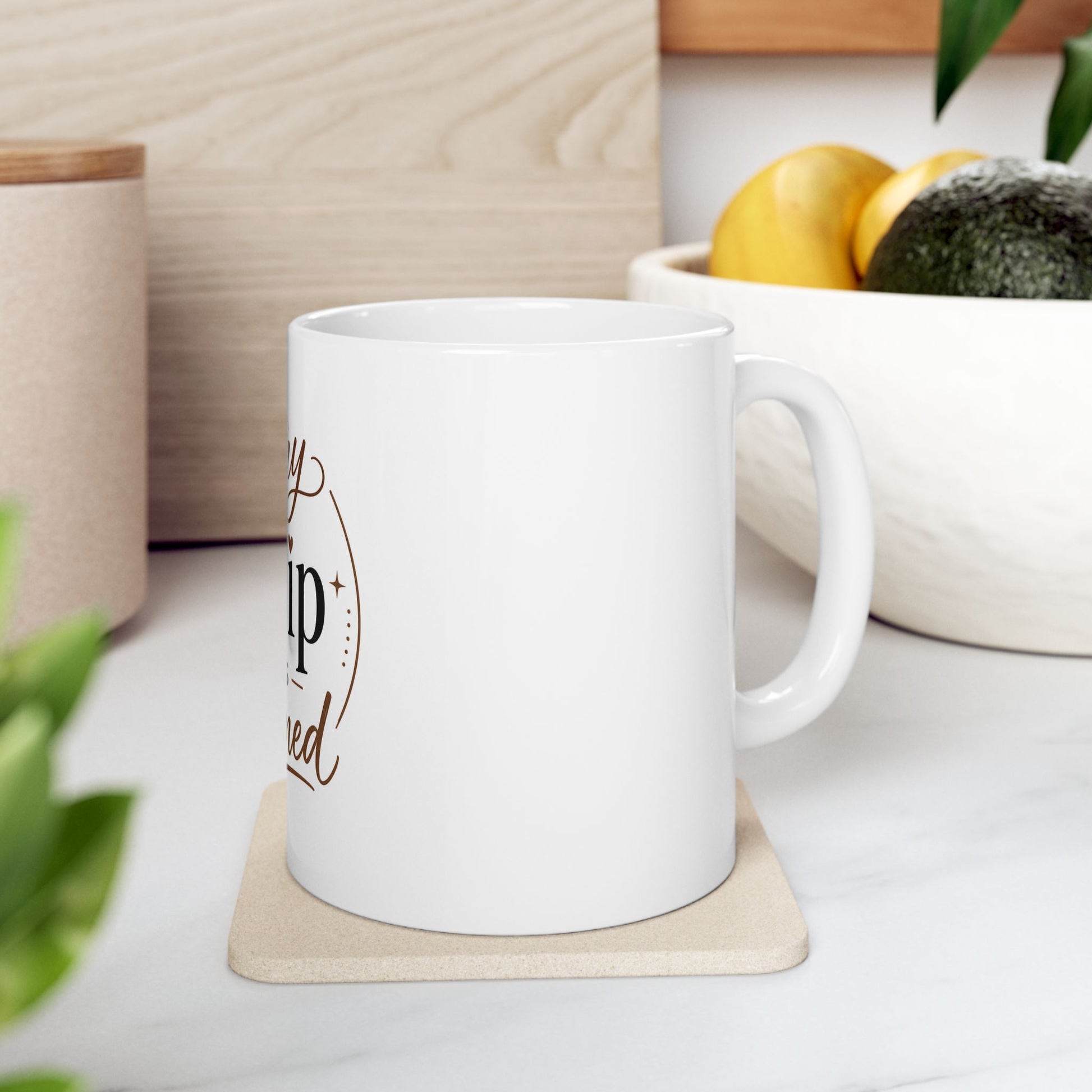 White coffee mug on wooden table with coffee and warm lighting showing Every Sip Is Earned inspirational design with heart symbol