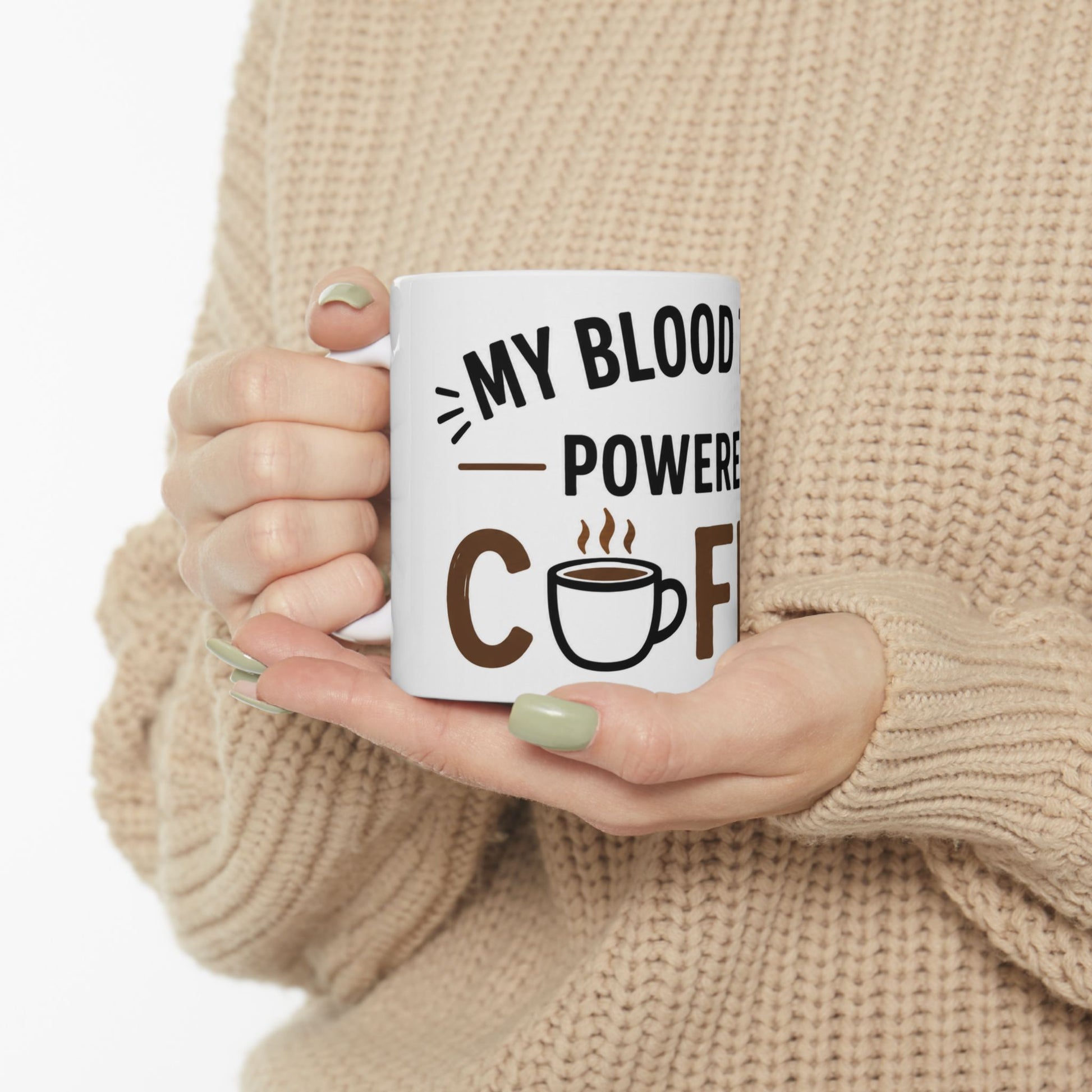 Person holding white coffee mug with My Blood Type Is Powered By Coffee funny caffeine quote design