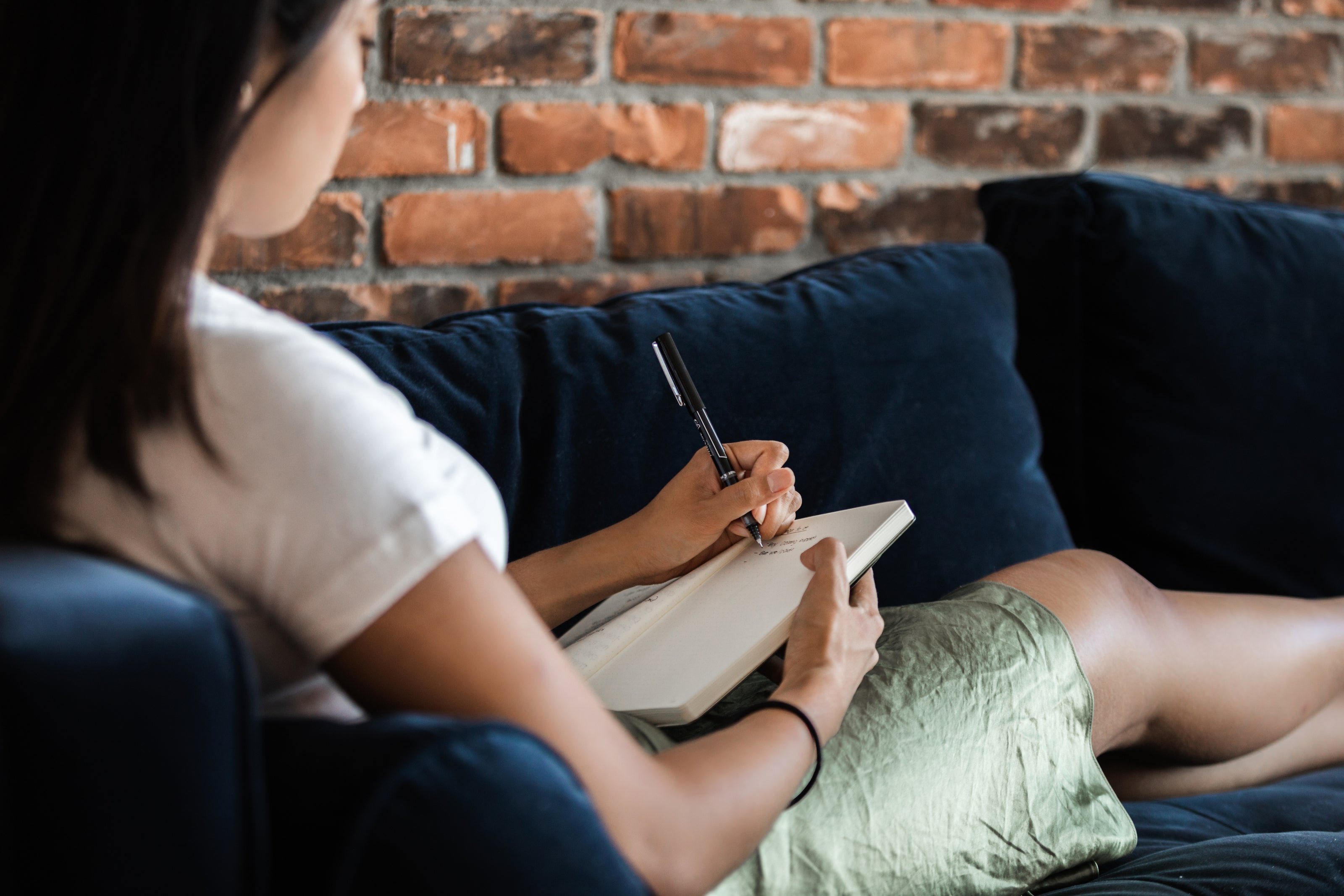 Person relaxing on couch with notebook while securely ordering coffee mugs online from home