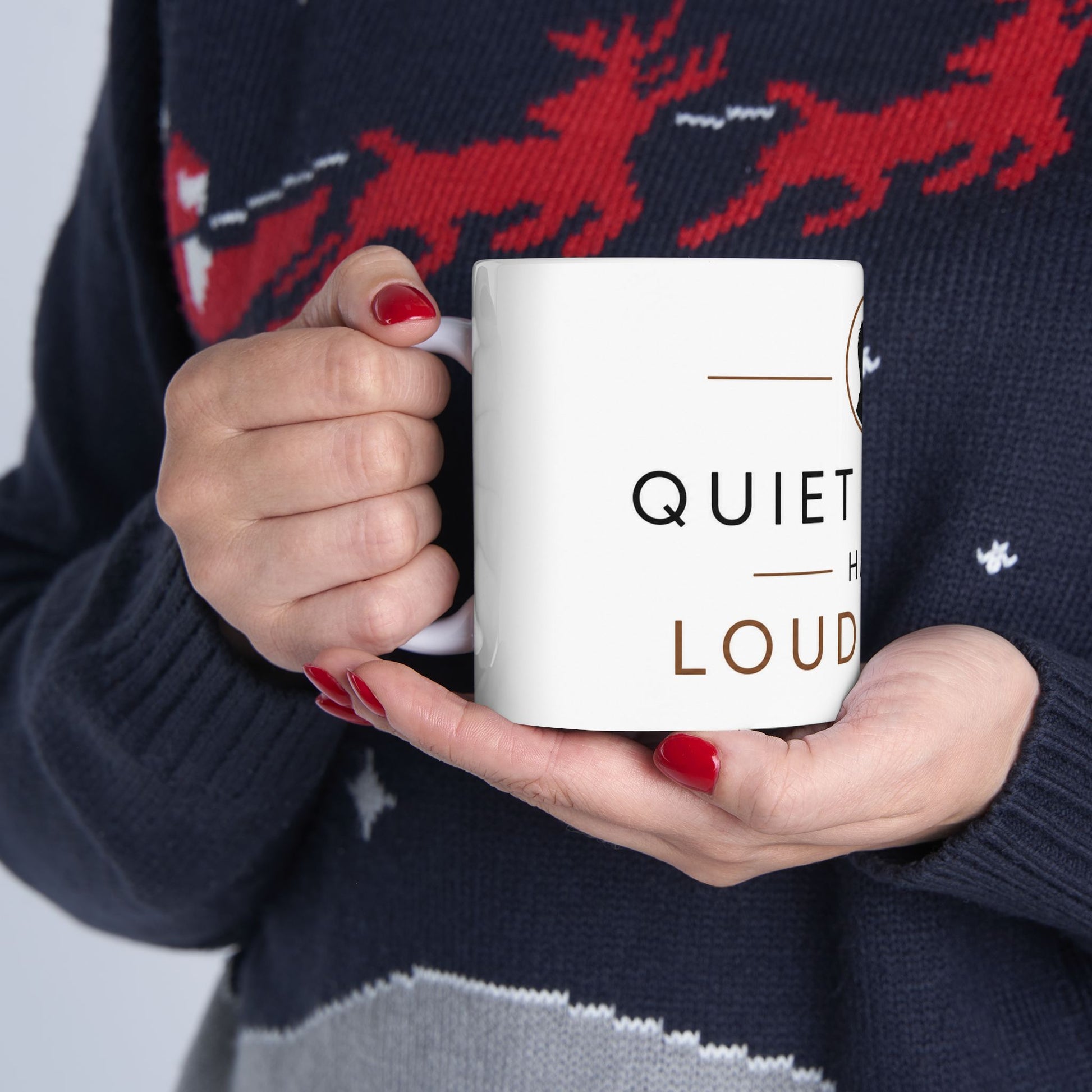 Person holding white coffee mug with Quiet People Have Loud Minds introvert quote design in natural lighting