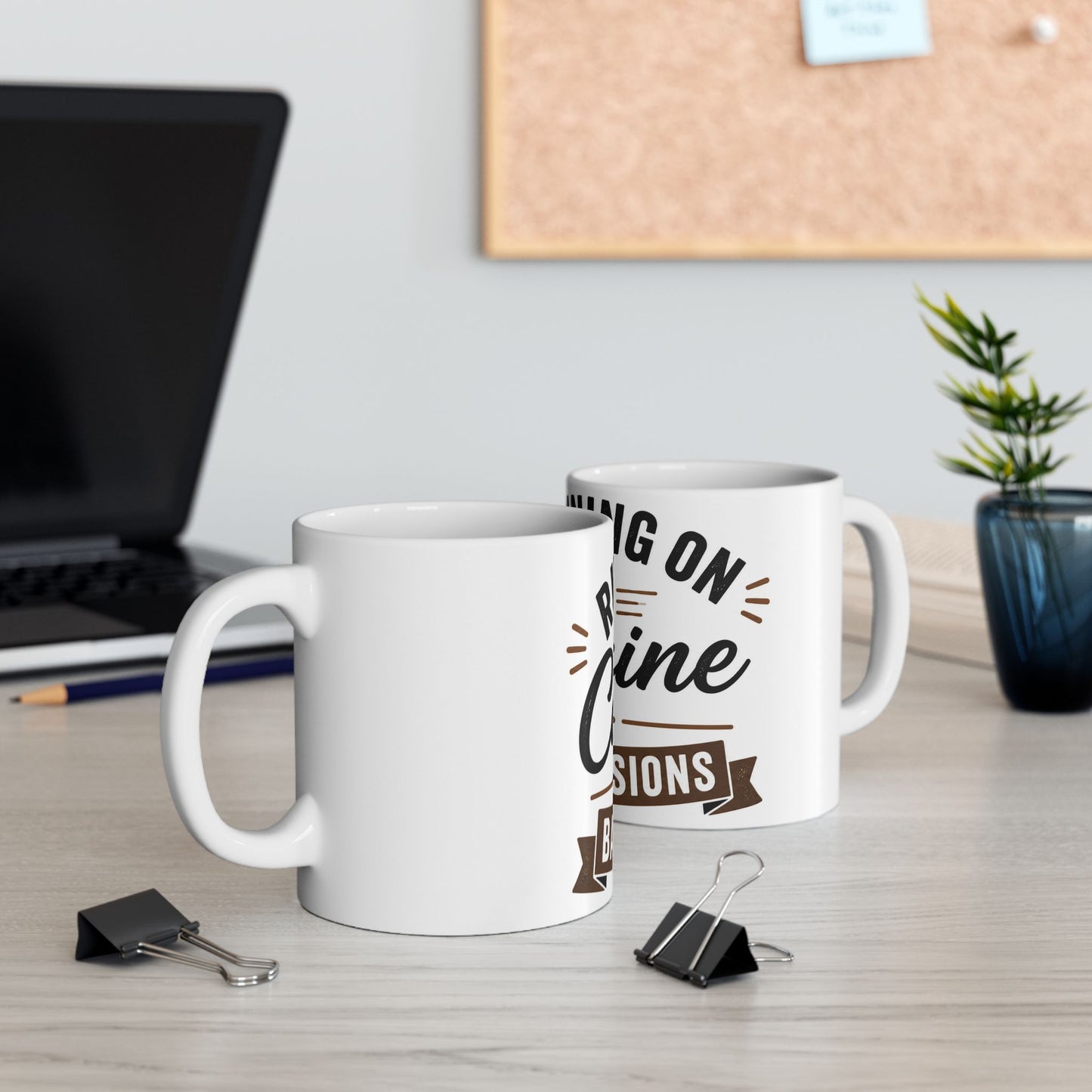 White coffee mug on desk next to computer showing Running on Caffeine and Bad Decisions funny coffee design in workspace setting